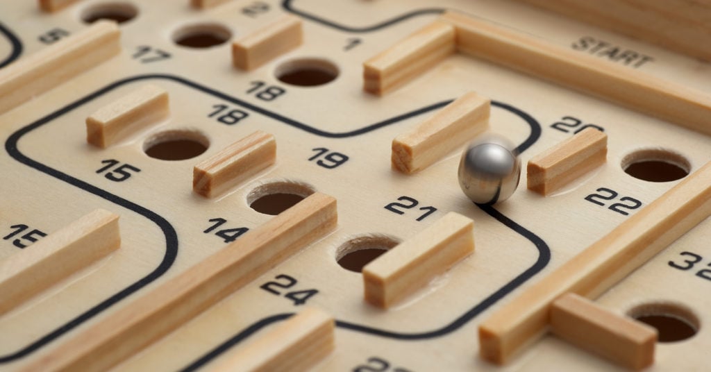 A challenging wooden maze game where a ball is manouvered to miss the holes.